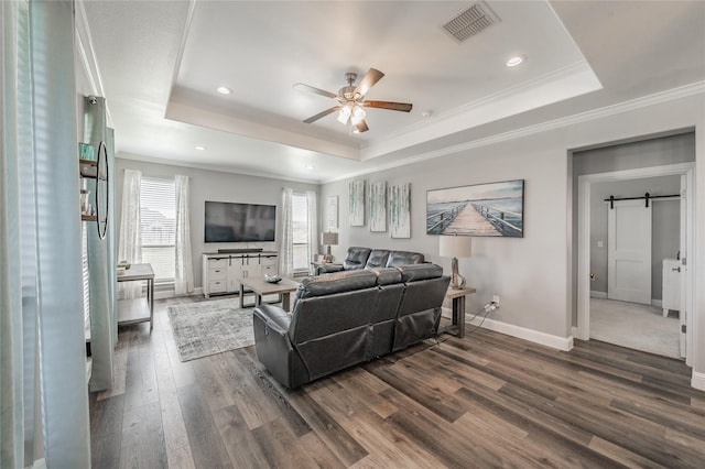 living area featuring ceiling fan, visible vents, a raised ceiling, baseboards, and dark wood-style floors