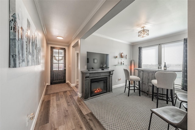 interior space with plenty of natural light, baseboards, wood finished floors, and ornamental molding