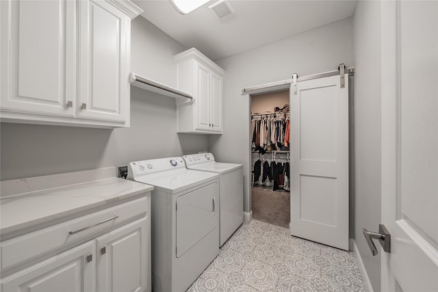 washroom with washing machine and clothes dryer, visible vents, and cabinet space