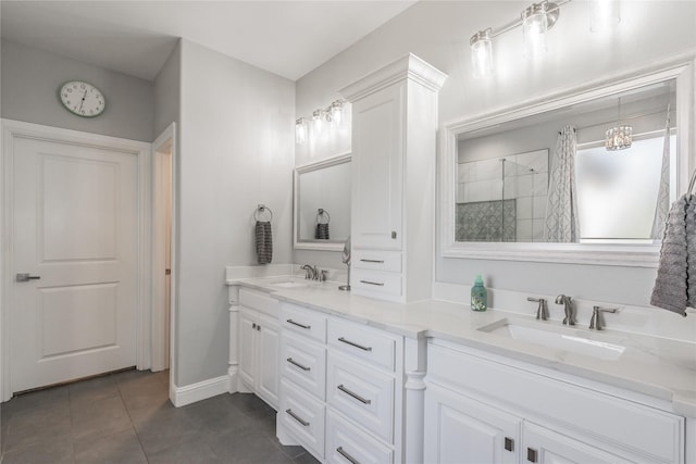 bathroom featuring baseboards, tile patterned flooring, tiled shower, and a sink