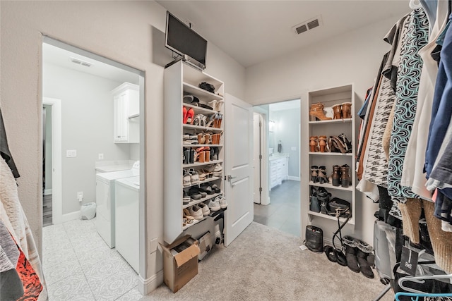 spacious closet featuring separate washer and dryer, visible vents, and light tile patterned floors