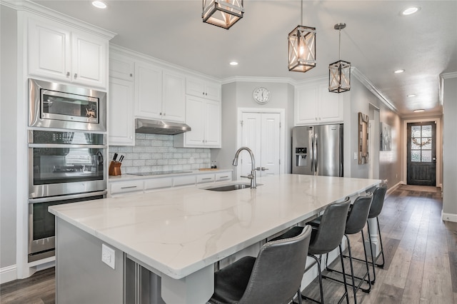 kitchen with a large island, white cabinetry, appliances with stainless steel finishes, and sink