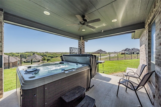 view of patio with fence, a hot tub, and ceiling fan