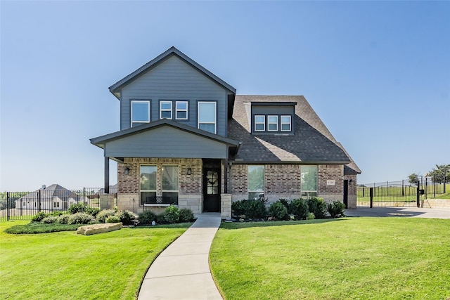 craftsman-style home with fence, brick siding, and a front yard