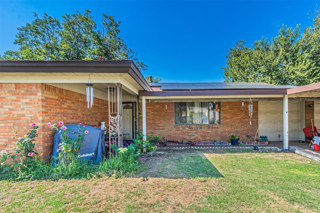 view of front facade featuring a front lawn and solar panels