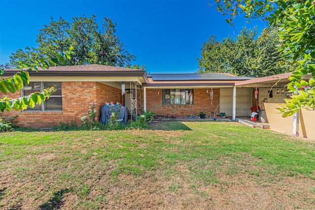 single story home featuring a front lawn and solar panels