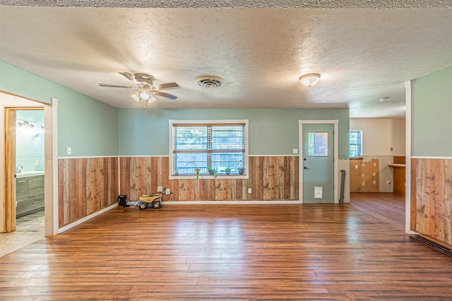 unfurnished room with a textured ceiling, ceiling fan, and hardwood / wood-style floors