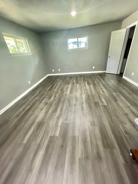 basement featuring a wealth of natural light and dark wood-type flooring