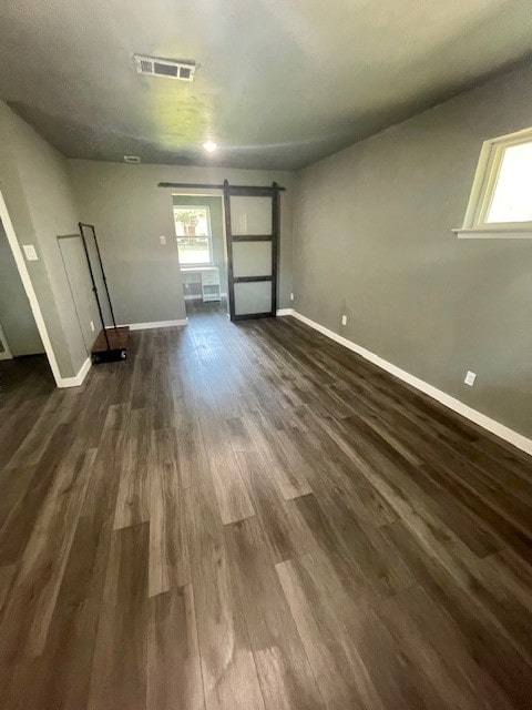 interior space featuring dark wood-type flooring and a barn door