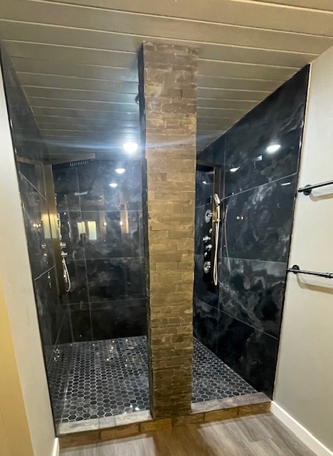 bathroom with hardwood / wood-style flooring and tiled shower