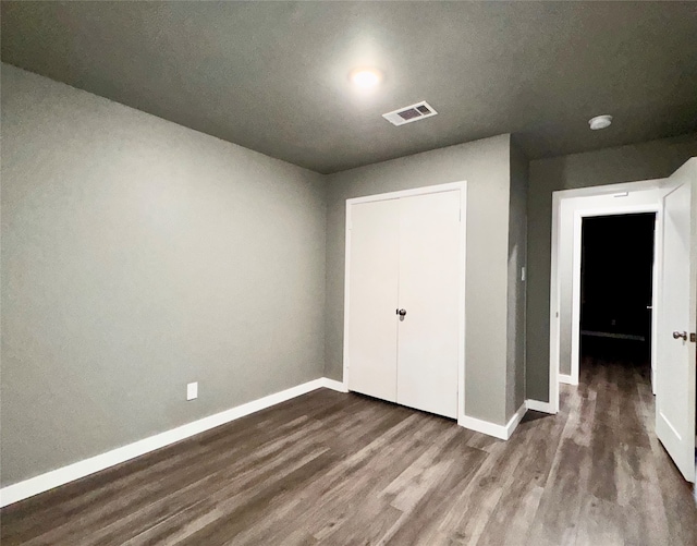 unfurnished bedroom with hardwood / wood-style flooring and a closet