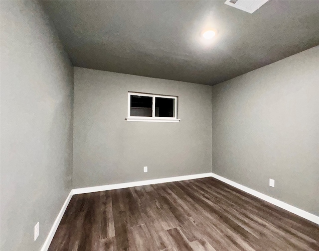 unfurnished room with dark wood-type flooring