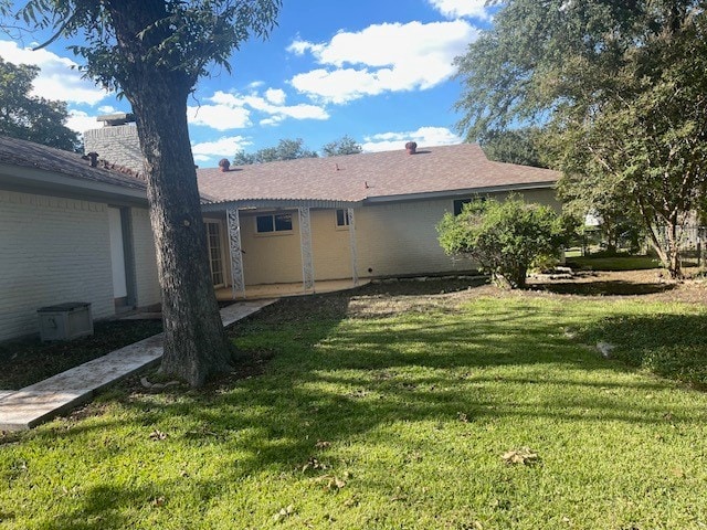 rear view of house with a yard