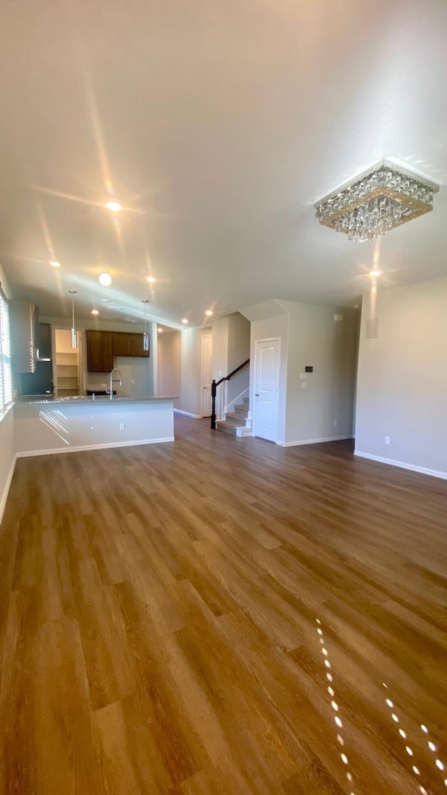 unfurnished living room featuring hardwood / wood-style floors and sink