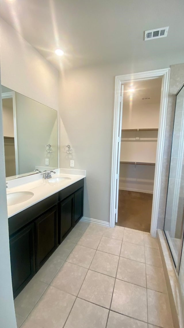 bathroom featuring vanity, tile patterned floors, and walk in shower