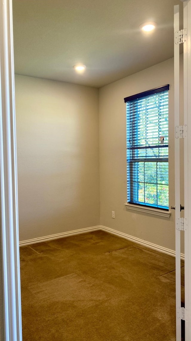 spare room with dark colored carpet