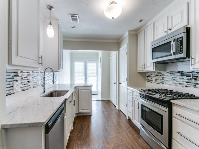 kitchen featuring sink, white cabinetry, appliances with stainless steel finishes, light stone countertops, and dark hardwood / wood-style flooring