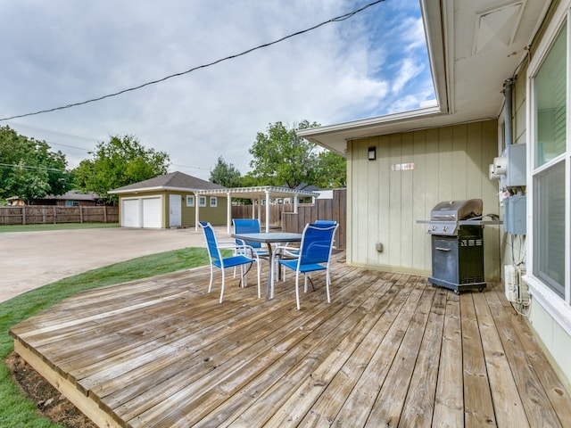 wooden deck with area for grilling, a patio area, an outdoor structure, and a garage