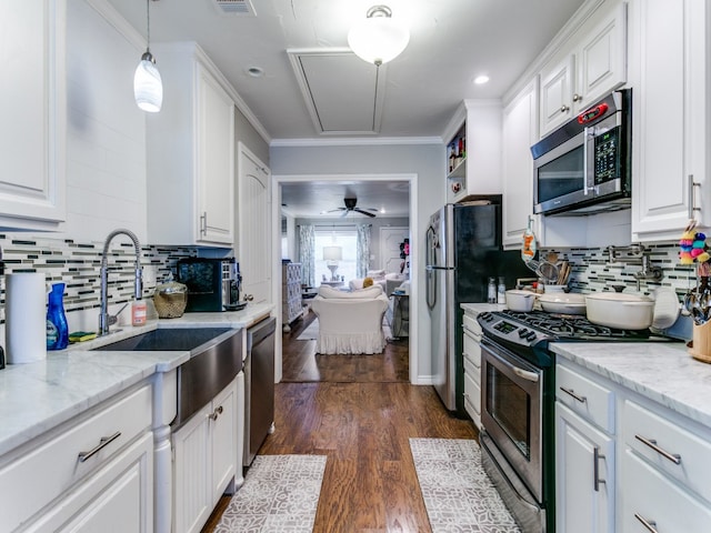 kitchen featuring white cabinets, stainless steel appliances, dark wood-type flooring, and decorative light fixtures