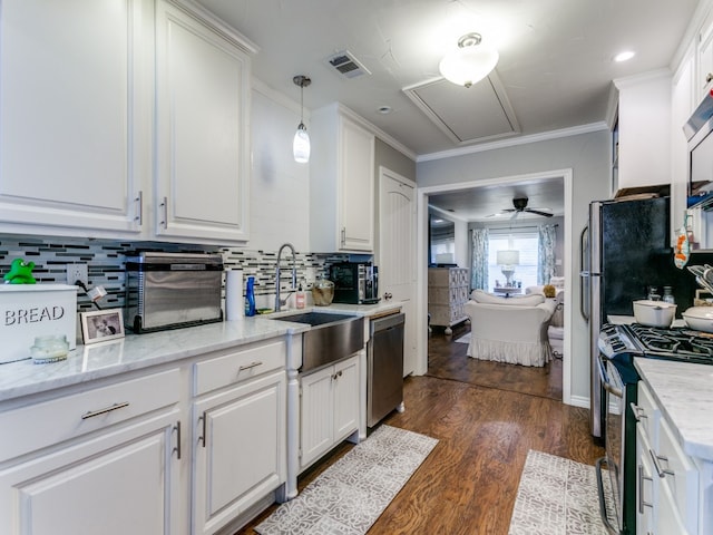 kitchen featuring pendant lighting, dark hardwood / wood-style flooring, white cabinetry, appliances with stainless steel finishes, and crown molding