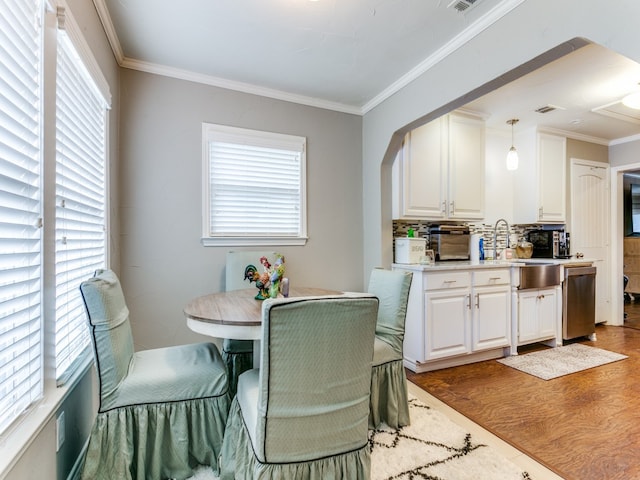 dining area featuring ornamental molding, a wealth of natural light, and dark wood-type flooring