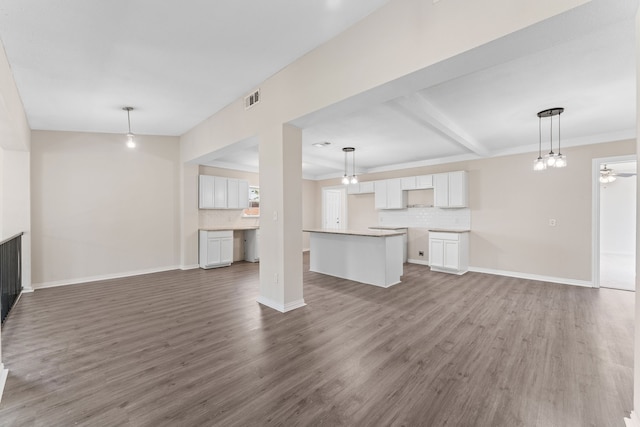 kitchen featuring sink, light stone countertops, a center island, white cabinets, and dark hardwood / wood-style flooring