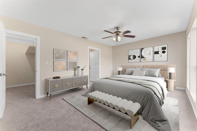 unfurnished bedroom featuring light colored carpet, ceiling fan, and ensuite bath