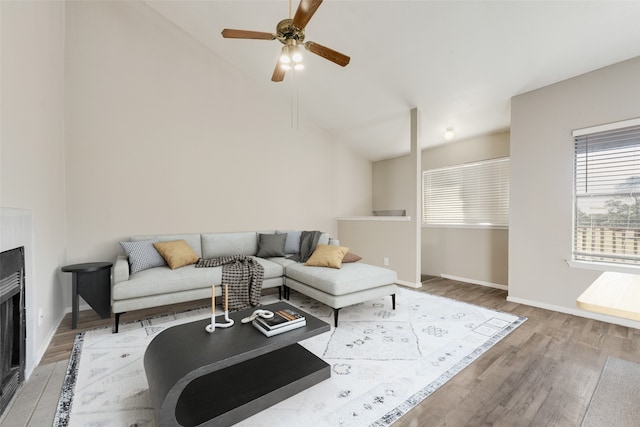 living room featuring ceiling fan, wood-type flooring, and lofted ceiling