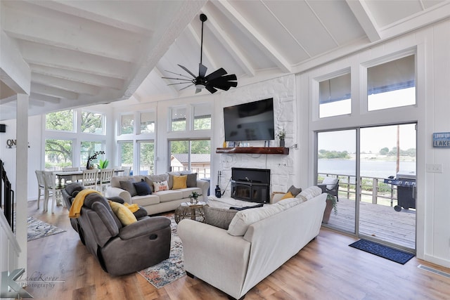 living room featuring ceiling fan, light hardwood / wood-style flooring, beam ceiling, and high vaulted ceiling