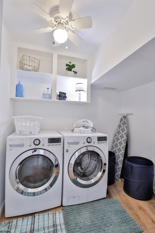 laundry room with washer and clothes dryer, light hardwood / wood-style floors, and ceiling fan