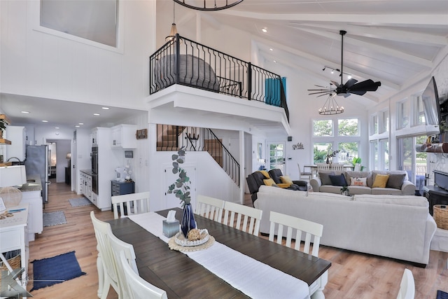 dining space featuring a notable chandelier, light hardwood / wood-style flooring, and high vaulted ceiling