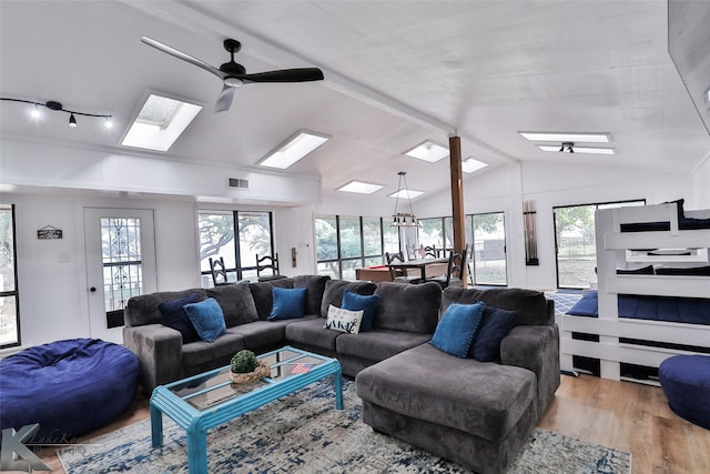 living room featuring light wood-type flooring, lofted ceiling, ceiling fan, and a wealth of natural light