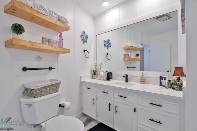 bathroom with crown molding, vanity, and toilet