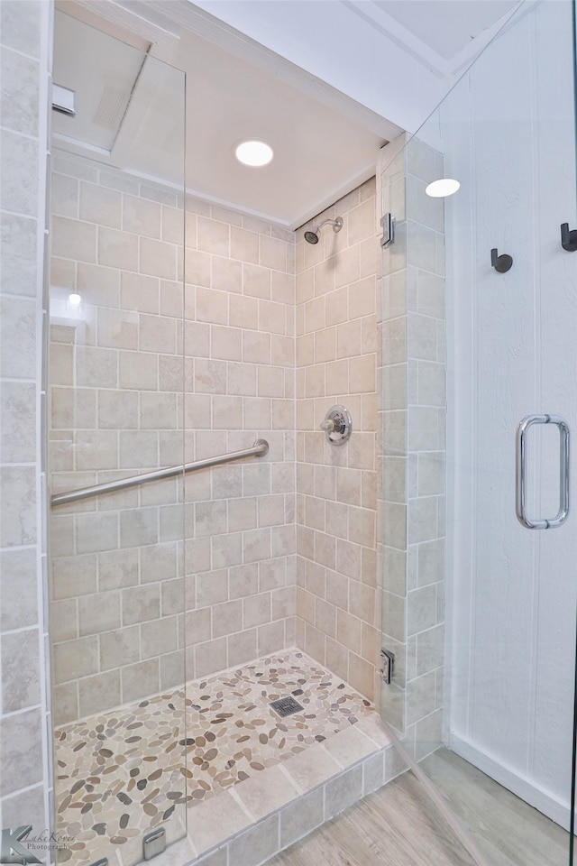 bathroom featuring hardwood / wood-style floors and a shower with shower door