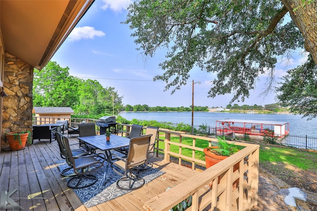 deck featuring a water view, a yard, and area for grilling