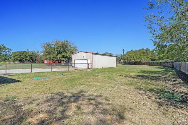 view of yard featuring a garage, an outdoor structure, and a rural view