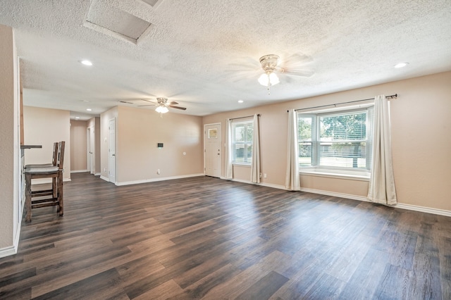 unfurnished living room with dark wood-type flooring, a textured ceiling, and ceiling fan