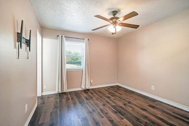 empty room featuring dark wood-type flooring, ceiling fan, and a textured ceiling