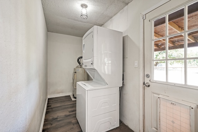 laundry room with dark wood-type flooring, water heater, a textured ceiling, and stacked washing maching and dryer