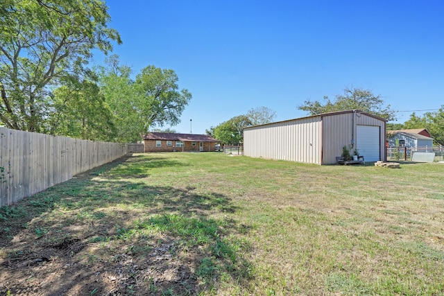 view of yard featuring a garage, an outdoor structure, and a fenced backyard