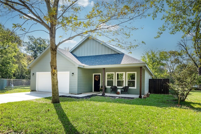 view of front of house with covered porch, a garage, and a front lawn