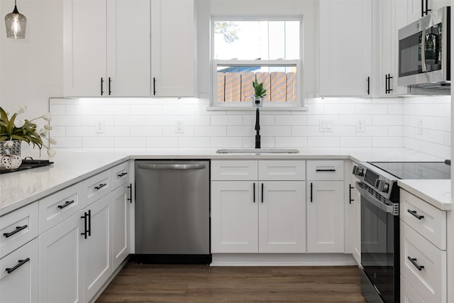 kitchen featuring white cabinets, appliances with stainless steel finishes, light stone counters, and sink