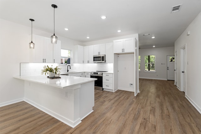 kitchen with sink, white cabinetry, stainless steel appliances, and a wealth of natural light