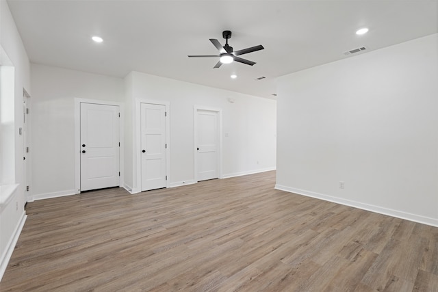 empty room with ceiling fan and light hardwood / wood-style flooring