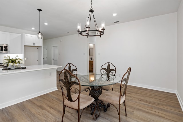 dining room featuring light hardwood / wood-style floors and a notable chandelier