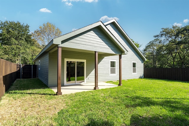 rear view of property featuring a patio area and a lawn