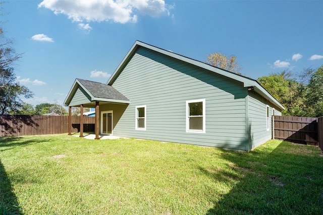 back of house with a yard and a patio