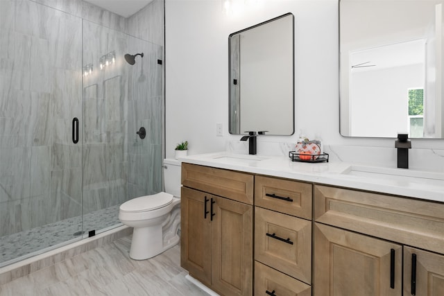 bathroom with a shower with door, vanity, and toilet