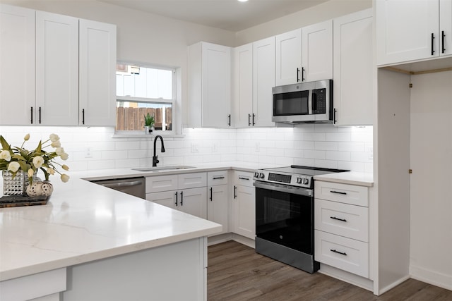 kitchen with white cabinets, dark hardwood / wood-style flooring, stainless steel appliances, and sink