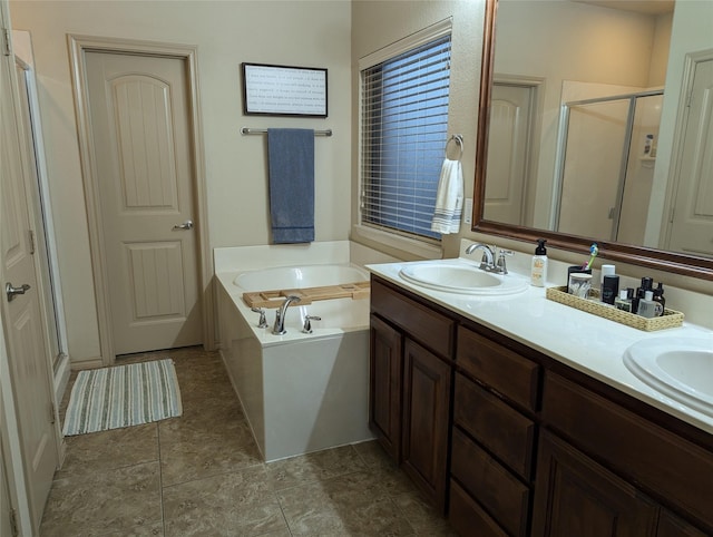 bathroom featuring a sink, a shower stall, double vanity, and a garden tub